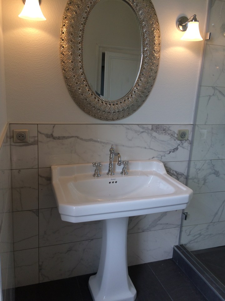 Mixing styles, classic fixtures, marble walls.